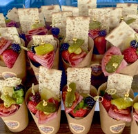 paper cups filled with fruit and crackers