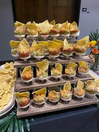 guacamole, chips and salsa on a wooden tray