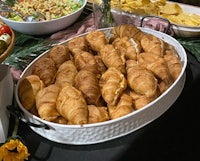 a table full of croissants and other food on a table