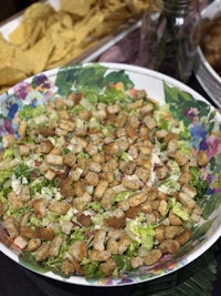 a salad with croutons and tortilla chips on a table