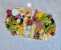 a tray with a variety of cheeses and fruits on it