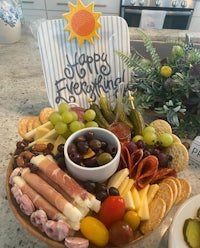 a platter of cheese and crackers with a sign that says happy everything