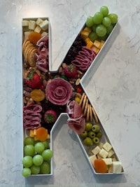 a letter k made out of fruit and cheese